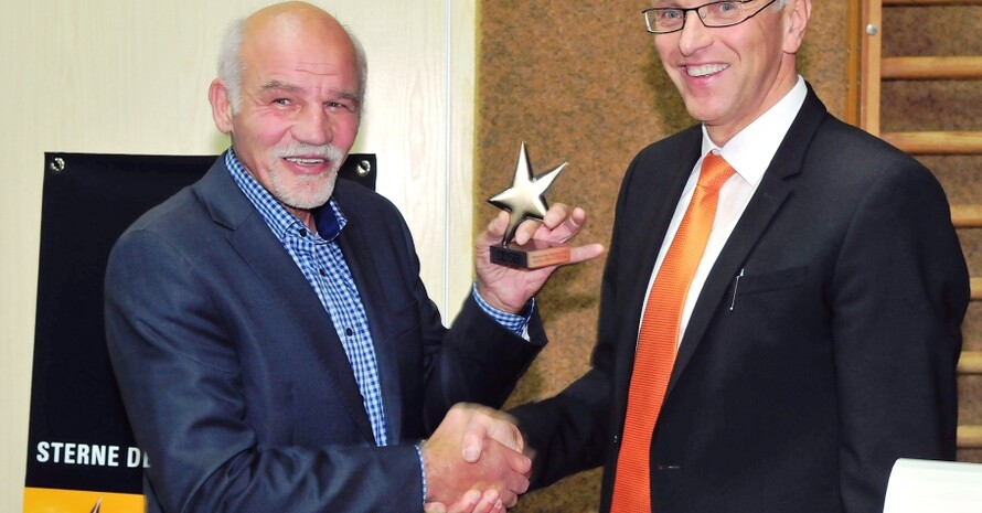 „Diese Anerkennung bedeutet uns sehr viel“: Reinhard Jassmann (links) nimmt hocherfreut die Auszeichnung von Udo Martin, Vorstand der Waldecker Bank, entgegen. (Quelle: Jassmann)